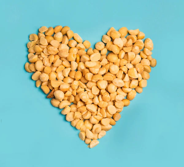 Macadamia nuts shaped like a heart on a blue background.